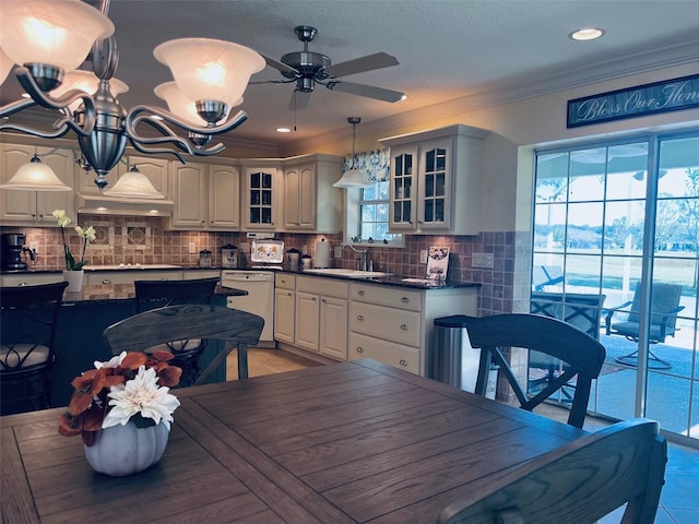 dining area with ceiling fan, crown molding, and sink