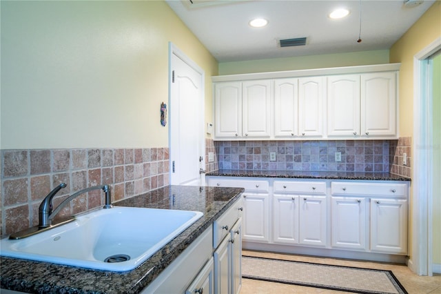 kitchen with white cabinets, decorative backsplash, light tile patterned flooring, and sink