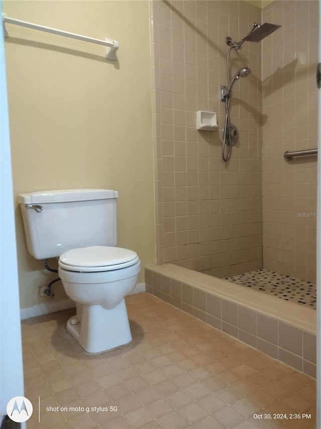 bathroom with toilet and a tile shower