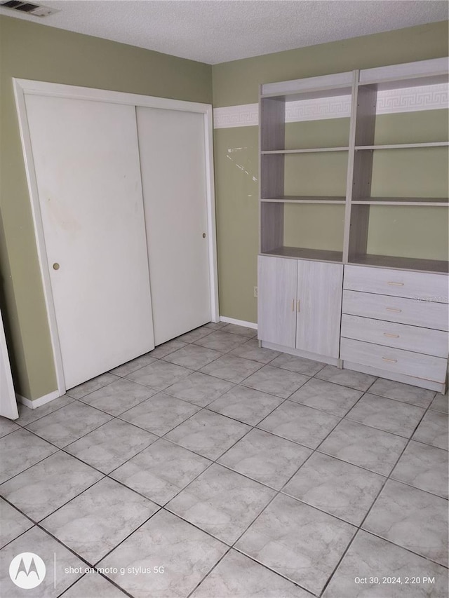 unfurnished bedroom featuring a closet and a textured ceiling