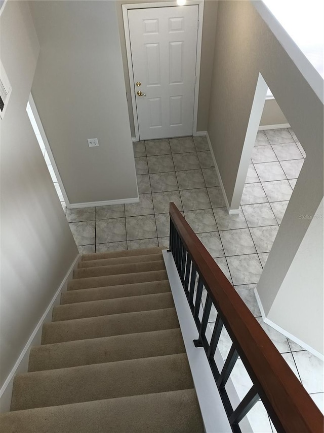 stairway featuring baseboards and tile patterned floors