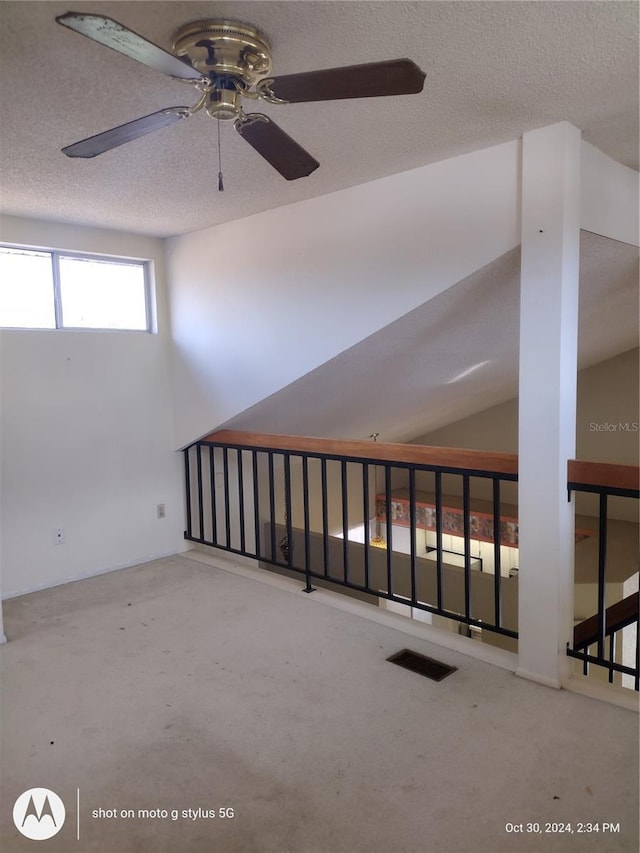 spare room with visible vents, vaulted ceiling, and a textured ceiling