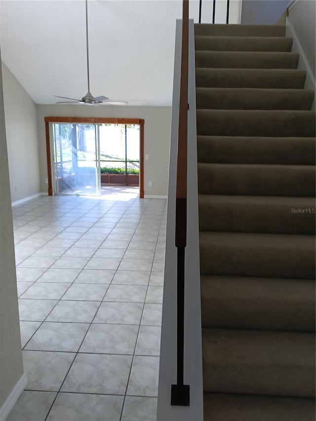 staircase featuring tile patterned flooring, ceiling fan, lofted ceiling, and baseboards