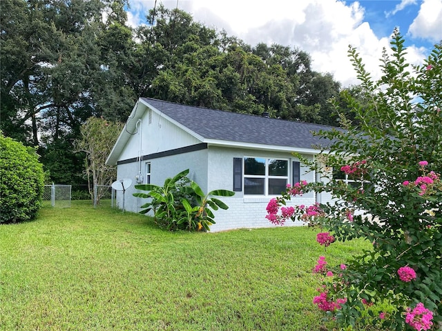 view of side of home with a yard