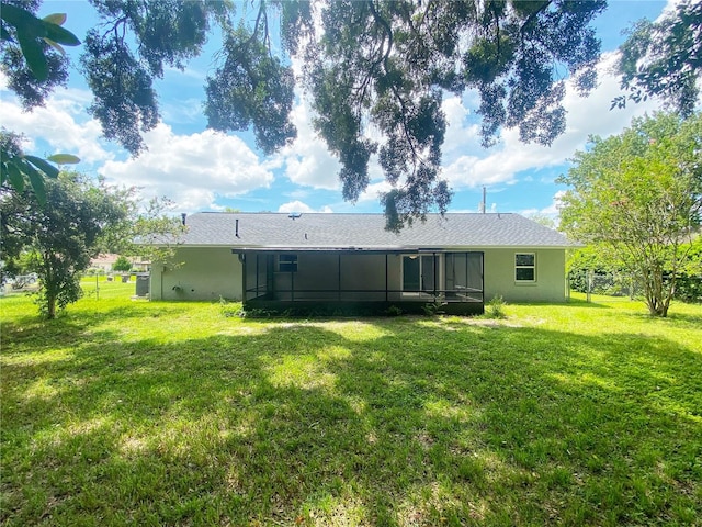 back of property featuring a lawn and a sunroom