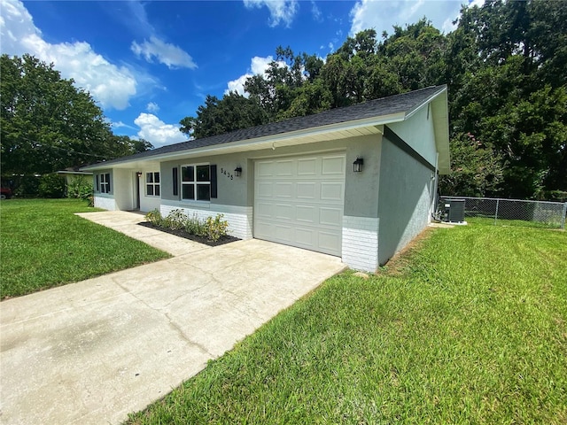 ranch-style house with a front lawn, a garage, and central AC