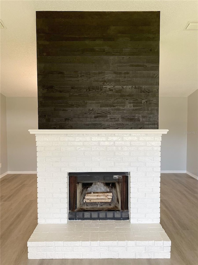 interior details featuring hardwood / wood-style flooring, a fireplace, and a textured ceiling