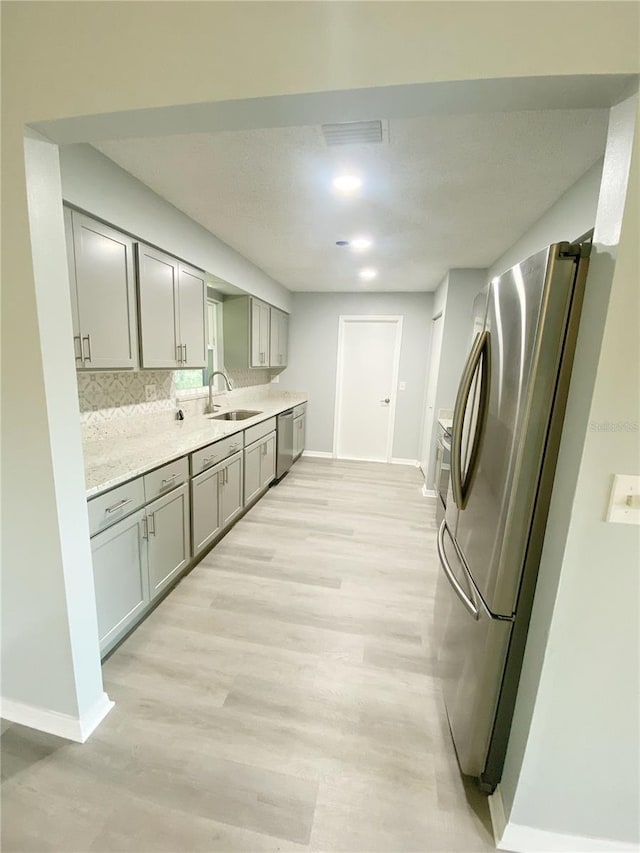 laundry room featuring light wood-type flooring and sink