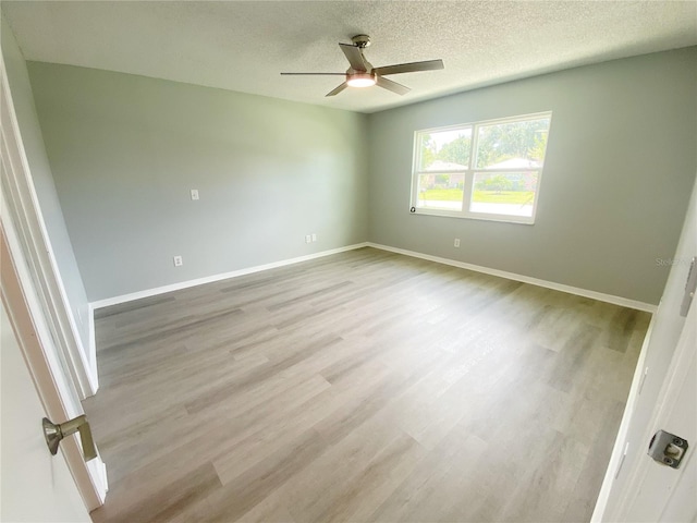 empty room with a textured ceiling, hardwood / wood-style flooring, and ceiling fan