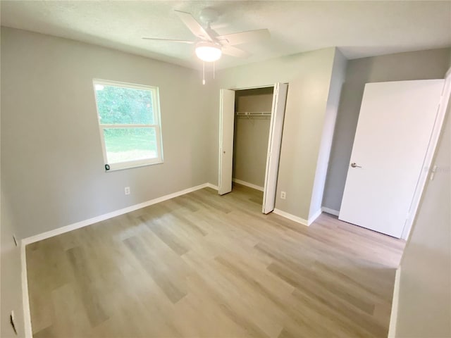 unfurnished bedroom featuring ceiling fan, a closet, and light hardwood / wood-style floors