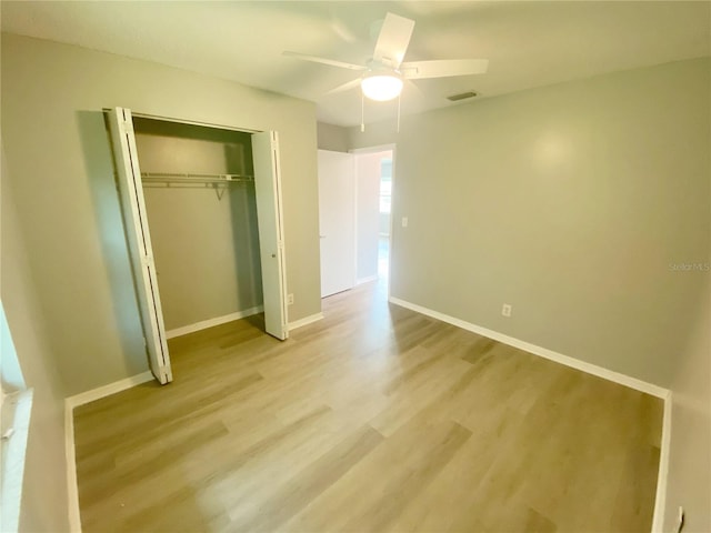 unfurnished bedroom with light wood-type flooring, a closet, and ceiling fan