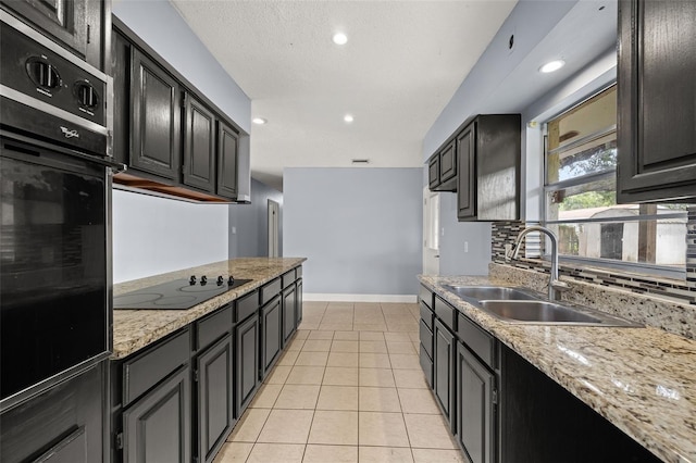 kitchen with black appliances, sink, decorative backsplash, light tile patterned floors, and light stone counters