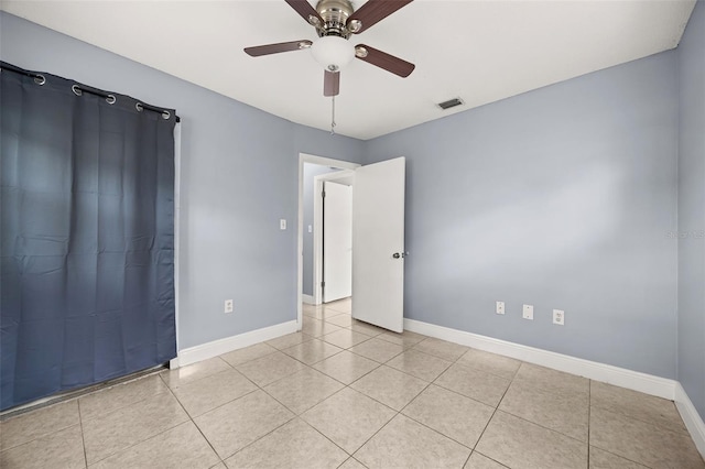 tiled empty room with ceiling fan