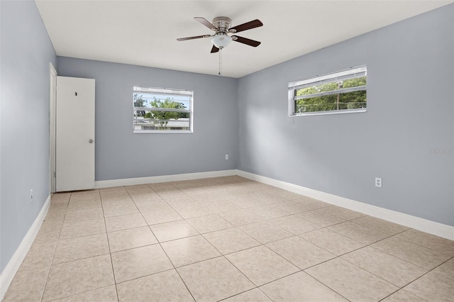 empty room with ceiling fan and light tile patterned floors