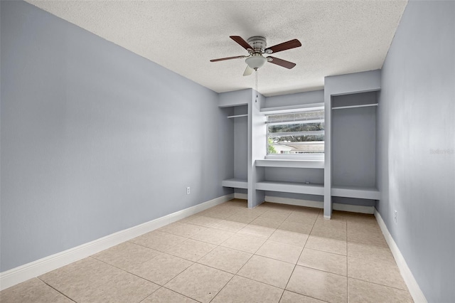 unfurnished bedroom featuring ceiling fan, light tile patterned flooring, and a textured ceiling