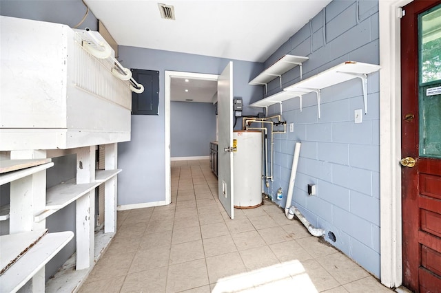 interior space with tile walls, light tile patterned floors, and gas water heater