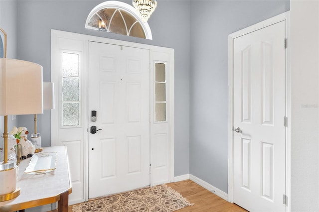 entrance foyer with light hardwood / wood-style floors and a notable chandelier