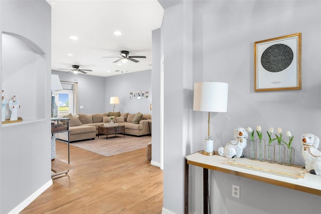 living room featuring light hardwood / wood-style floors and ceiling fan