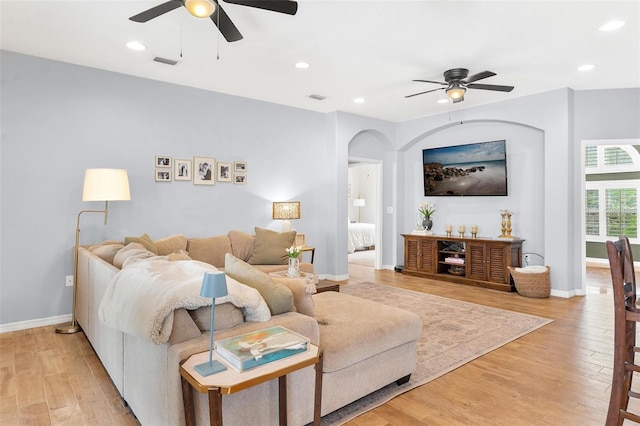 living room with ceiling fan and light hardwood / wood-style flooring