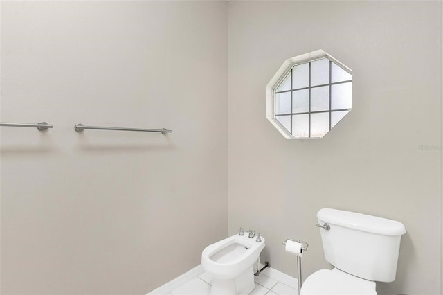 bathroom with tile patterned flooring, toilet, and a bidet