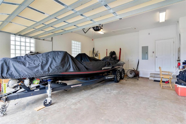 garage featuring electric panel, a garage door opener, and a carport