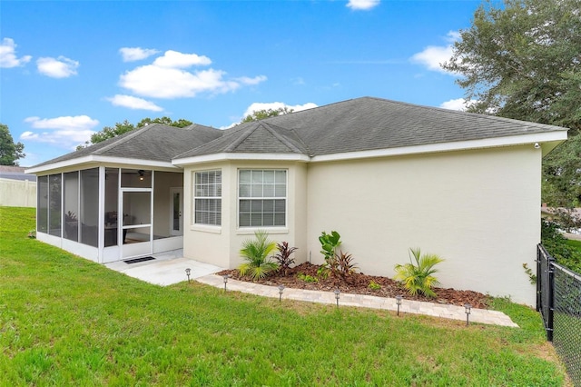 back of house featuring a sunroom and a yard