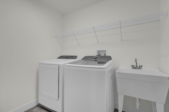 clothes washing area with washer and dryer and sink