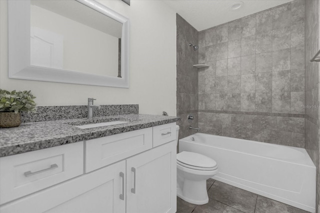 full bathroom with vanity, tiled shower / bath combo, toilet, and tile patterned flooring