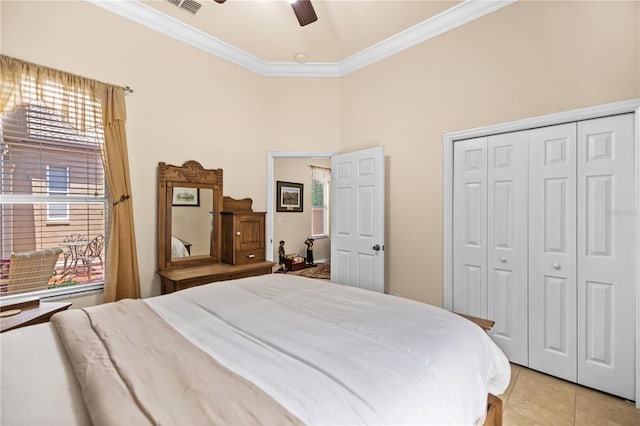 tiled bedroom with a closet, ceiling fan, and ornamental molding