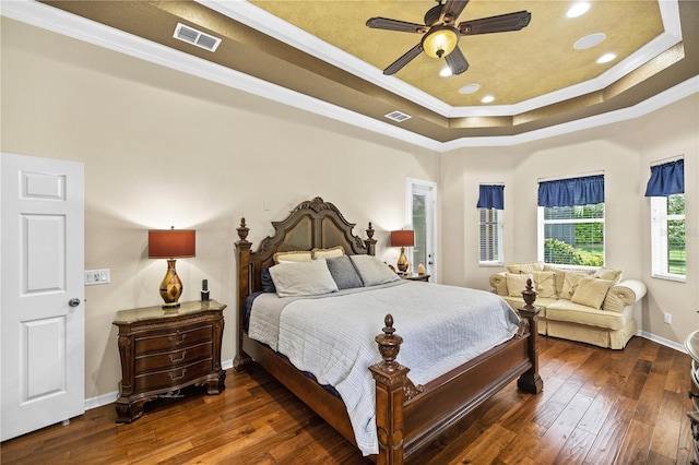 bedroom featuring ceiling fan, dark hardwood / wood-style flooring, ornamental molding, and a tray ceiling