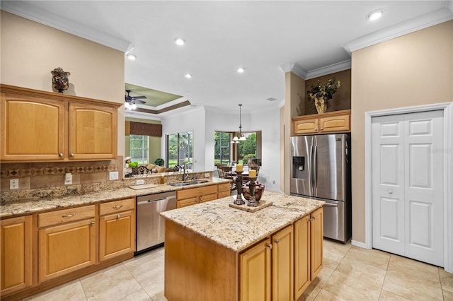 kitchen featuring stainless steel appliances, backsplash, pendant lighting, a kitchen island, and ornamental molding