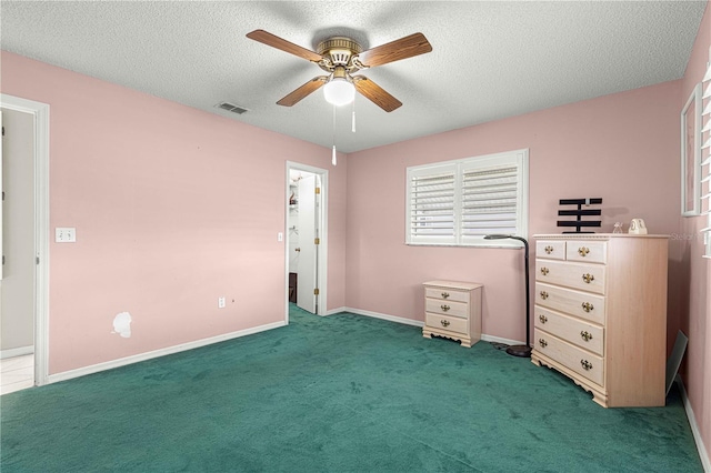 unfurnished bedroom with ceiling fan, dark colored carpet, and a textured ceiling