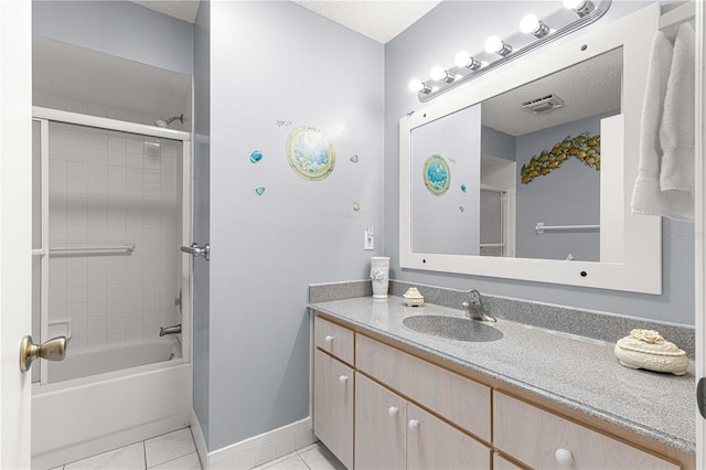 bathroom featuring vanity, a textured ceiling, tile patterned floors, and enclosed tub / shower combo