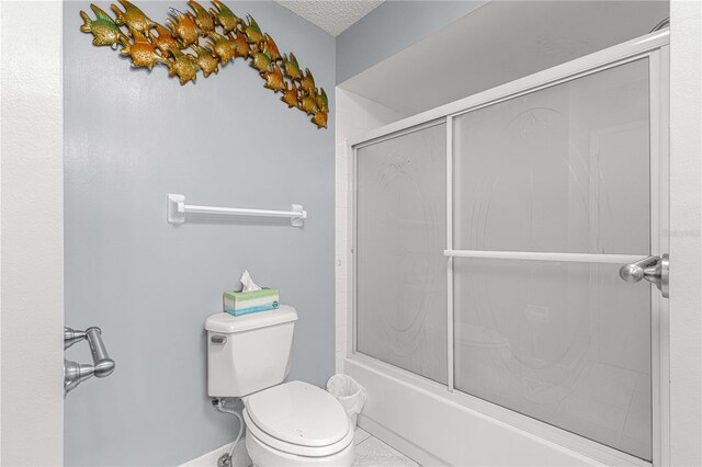 bathroom with shower / bath combination with glass door, toilet, and a textured ceiling