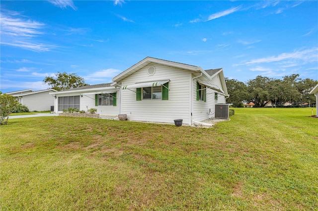 view of front of house featuring central AC and a front yard