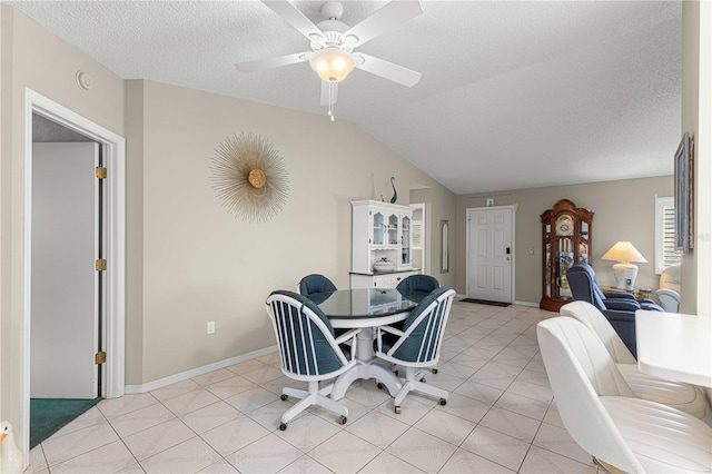 tiled dining area with a textured ceiling, ceiling fan, and lofted ceiling