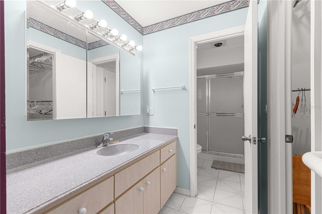 bathroom with vanity, toilet, an enclosed shower, and tile patterned flooring