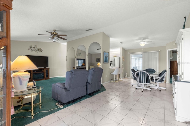 living room with ceiling fan and a textured ceiling