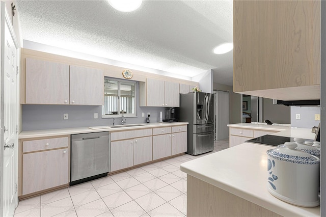 kitchen featuring a textured ceiling, stainless steel appliances, kitchen peninsula, sink, and light brown cabinets