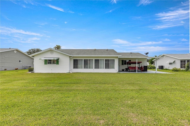 back of property with a lawn, a patio, and central AC