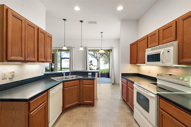 kitchen with hanging light fixtures, sink, light tile patterned floors, and white appliances