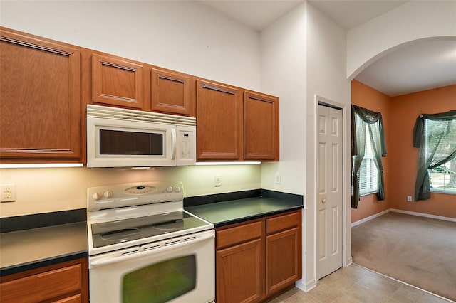 kitchen featuring light carpet and white appliances