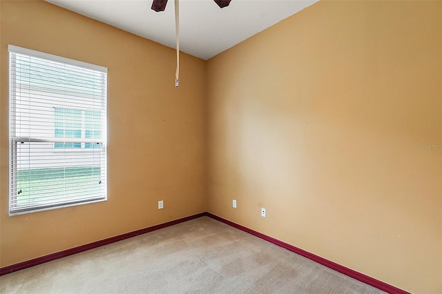 carpeted spare room featuring ceiling fan and a healthy amount of sunlight