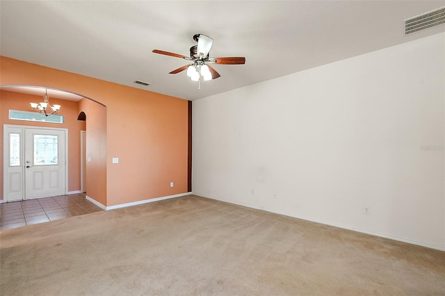 unfurnished room with ceiling fan with notable chandelier and light colored carpet