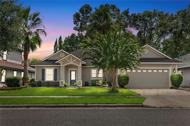 view of front of property featuring a garage and a yard