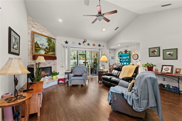 living room featuring ceiling fan, dark hardwood / wood-style floors, a stone fireplace, and high vaulted ceiling