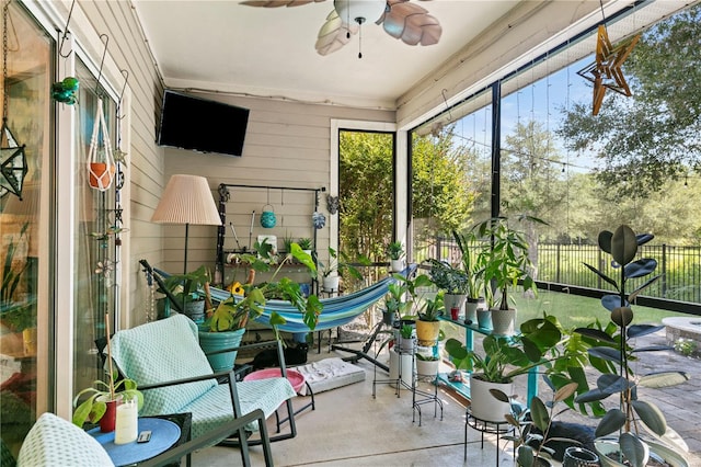 sunroom / solarium featuring ceiling fan