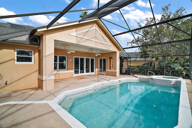 view of pool featuring an in ground hot tub, french doors, ceiling fan, glass enclosure, and a patio area