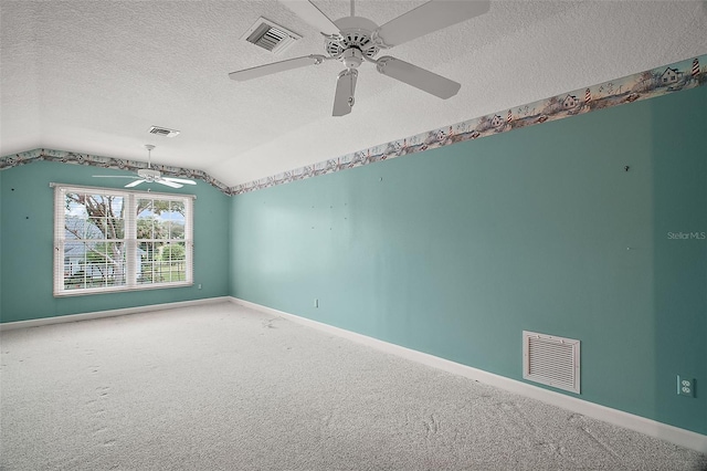 spare room featuring vaulted ceiling, ceiling fan, carpet floors, and a textured ceiling