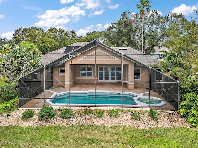 view of pool with an in ground hot tub, glass enclosure, and a patio area